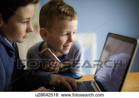 Stock Photo - Boys using laptop. Fotosearch