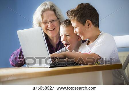 Boys using laptop with grandmother View Large Photo Image Stock Photo - Boys using laptop with grandmother. Fotosearch