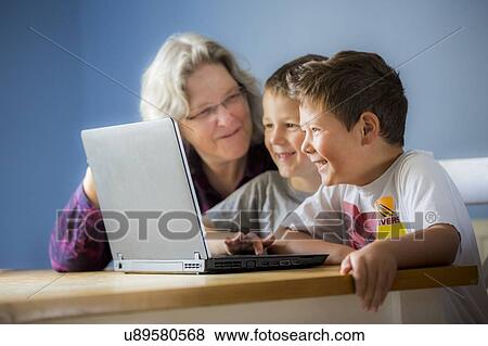 Boys using laptop with grandmother View Large Photo Image Stock Photo - Boys using laptop with grandmother. Fotosearch