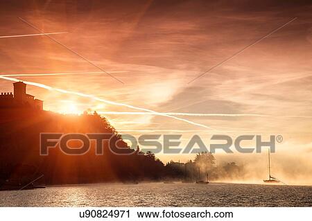 Bright sunlight behind cliffs, Lake Maggiore, Piedmont, Lombardy, Italy View Large Photo Image Stock Image - Bright sunlight behind cliffs, Lake Maggiore, Piedmont, Lombardy, Italy. Fotosearch