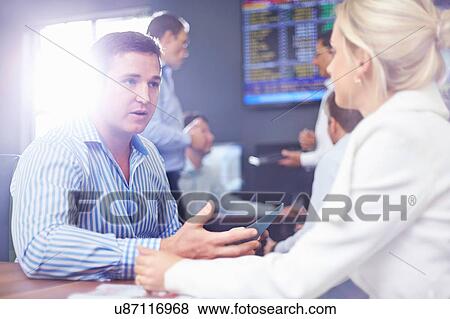 Stock Photo - Business man and business woman in office face to face having discussion. Fotosearch