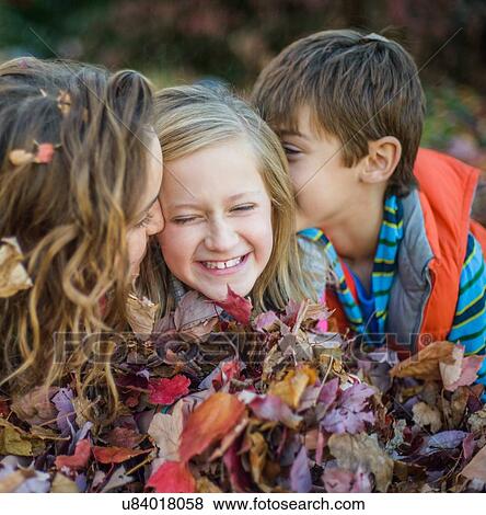 Children lying on autumn leaves in garden View Large Photo Image Stock Photo - Children lying on autumn leaves in garden. Fotosearch