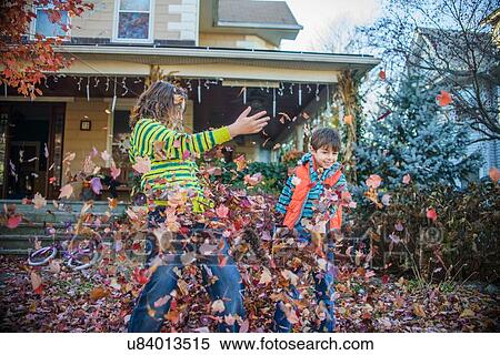 Children playing with autumn leaves in garden View Large Photo Image Stock Photography - Children playing with autumn leaves in garden. Fotosearch