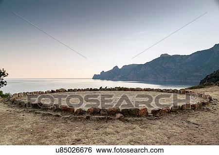 Stock Photograph - Circle of rocks on beach, Girolata, Corsica, France. Fotosearch