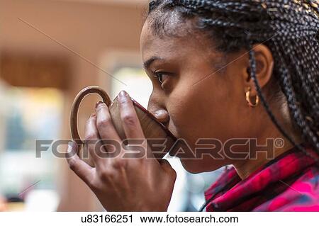 Close up of mid adult woman in kitchen drinking coffee View Large Photo Image Stock Image - Close up of mid adult woman in kitchen drinking coffee. Fotosearch