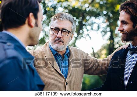 Close up portrait of proud mature man and two adult sons in park View Large Photo Image Stock Photo - Close up portrait of proud mature man and two adult sons in park. Fotosearch