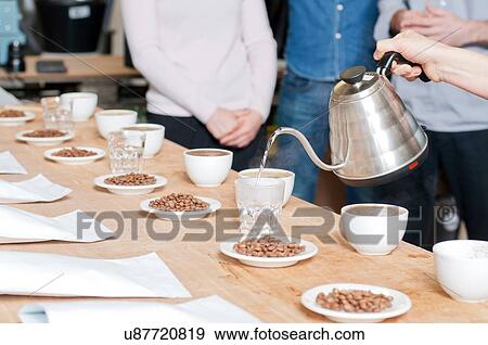 Stock Photo - Coffee seller pouring hot water into glass. Fotosearch