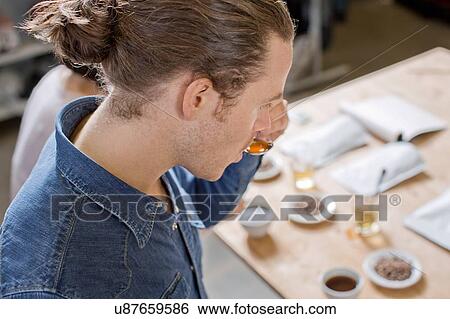Stock Photograph - Coffee taster sipping coffee with spoon. Fotosearch