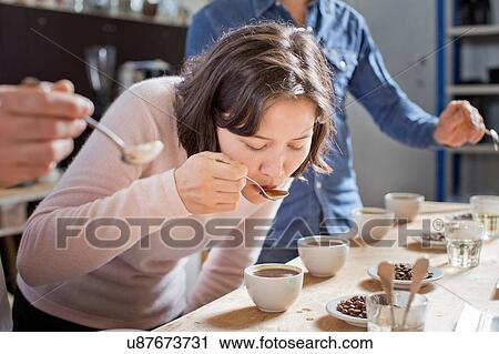 Stock Image - Coffee tasters sipping coffee with spoon. Fotosearch