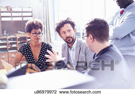 Stock Image - Colleagues in office chatting. Fotosearch