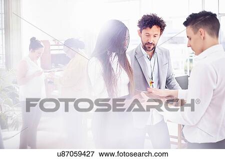Stock Photo - Colleagues in team building task face to face holding hands. Fotosearch