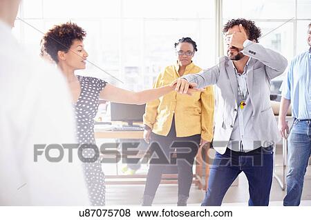Colleagues in team building task, holding hands covering eyes View Large Photo Image Stock Photo - Colleagues in team building task, holding hands covering eyes. Fotosearch