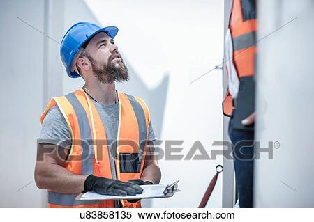 Construction worker talking to foreman from doorway of cabin on construction site View Large Photo Image Stock Photography - Construction worker talking to foreman from doorway of cabin on construction site. Fotosearch