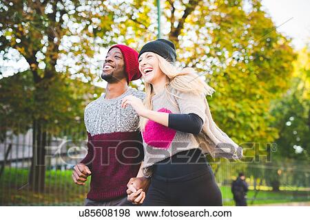 Stock Photo - Couple skipping in park. Fotosearch