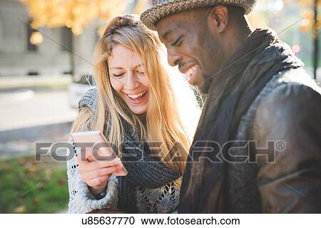 Stock Image - Couple using smartphone. Fotosearch
