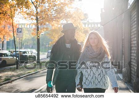 Stock Image - Couple walking on pavement. Fotosearch