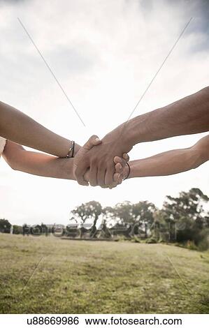 Cropped low angle view of young couple holding hands View Large Photo Image Stock Photograph - Cropped low angle view of young couple holding hands. Fotosearch