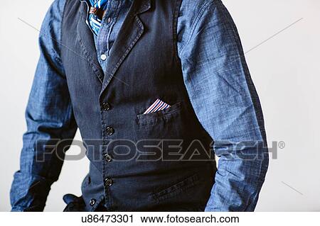 Stock Image - Cropped shot of mature man wearing tailored denim shirt and waistcoat. Fotosearch