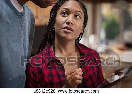 Cropped shot of mid adult couple using digital tablet in kitchen View Large Photo Image Stock Photo - Cropped shot of mid adult couple using digital tablet in kitchen. Fotosearch