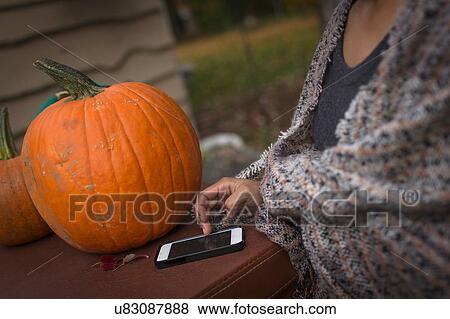 Cropped shot of mid adult woman using smartphone touchscreen in garden View Large Photo Image Stock Photo - Cropped shot of mid adult woman using smartphone touchscreen in garden. Fotosearch