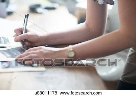 Stock Photo - Cropped shot of waitress's hands writing order notes in cafe. Fotosearch