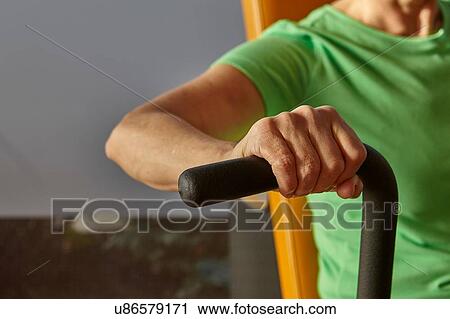 Stock Image - Cropped shot of woman exercising on gym exercise machine. Fotosearch