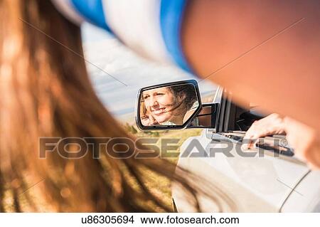 Picture - Cropped shot of young woman in off road vehicle mirror. Fotosearch