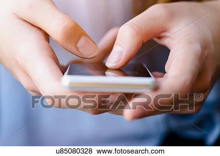 Cropped view of young womans texting on smartphone View Large Photo Image Stock Photo - Cropped view of young womans texting on smartphone. Fotosearch
