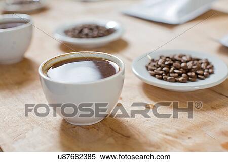 Stock Photography - Cups of coffee, saucers of coffee beans. Fotosearch