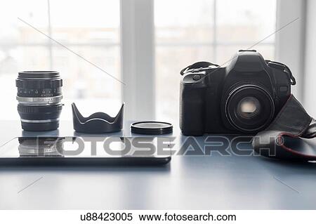 Stock Photography - Digital tablet and digital SLR camera on studio desk. Fotosearch