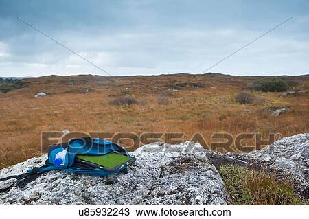 Stock Image - Digital tablet in backpack lying on rock, Connemara, Ireland. Fotosearch