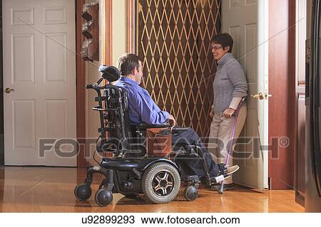 Stock Image - Disabled couple entering a home elevator. Fotosearch