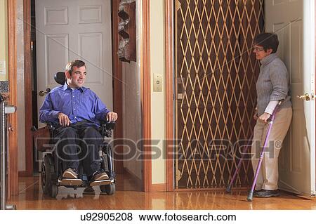 Stock Photo - Disabled couple entering a home elevator. Fotosearch