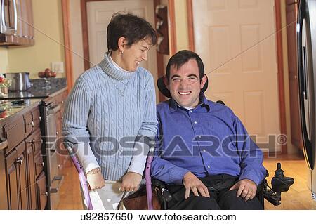 Stock Image - Disabled couple in accessible kitchen. Fotosearch