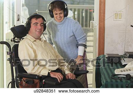 Stock Image - Disabled couple using headphones. Fotosearch