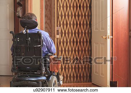 Stock Image - Disabled man entering a home elevator. Fotosearch