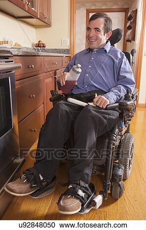 Stock Image - Disabled man in his kitchen. Fotosearch