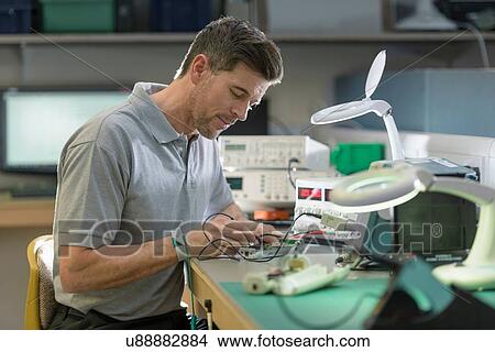 Electronics engineer assembling components in electronics factory View Large Photo Image Picture - Electronics engineer assembling components in electronics factory. Fotosearch