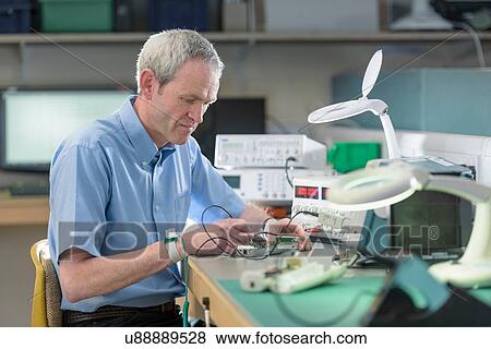 Electronics engineer assembling components in electronics factory View Large Photo Image Stock Photo - Electronics engineer assembling components in electronics factory. Fotosearch
