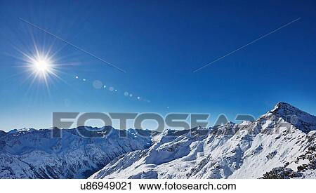 Elevated view of sunlight and blue sky over snow covered mountains, Gaislachkogel, Soelden, Tyrol, Austria View Large Photo Image Stock Image - Elevated view of sunlight and blue sky over snow covered mountains, Gaislachkogel, Soelden, Tyrol, Austria. Fotosearch