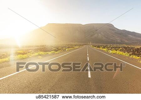 Empty sunlit road in volcanic landscape, La Oliva, Fuerteventura, Spain View Large Photo Image Stock Photo - Empty sunlit road in volcanic landscape, La Oliva, Fuerteventura, Spain. Fotosearch
