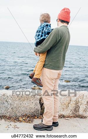 "Father holding son beside lake, rear view" View Large Photo Image Stock Image - "Father holding son beside lake, rear view". Fotosearch
