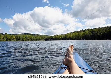 Stock Image - "Feet up on canoe, New Milford, Pennsylvania, US". Fotosearch