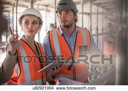 Female and male builders using digital tablet on construction site View Large Photo Image Picture - Female and male builders using digital tablet on construction site. Fotosearch