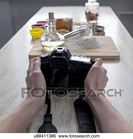 Stock Photograph - Female photographers hands photographing baking ingredients on counter. Fotosearch