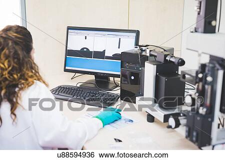 Stock Photograph - Female scientist analyzing obtained contact angle data. Fotosearch