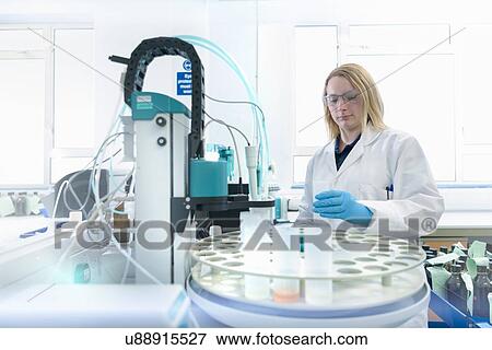 Stock Photo - Female scientist at workstation testing oil samples. Fotosearch
