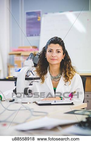 Stock Photo - Female scientist using optical microscope. Fotosearch