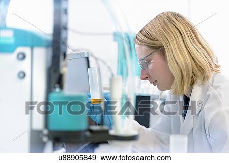 Stock Photo - Female scientist with oil sample in testing facility. Fotosearch