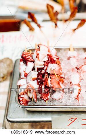 Stock Photo - Food stall with tray of octopus and ice, Japan. Fotosearch